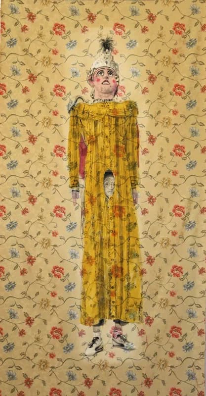 Figura femminile alta e frontale, con volto truccato e copricapo piumato, indossa una lunga veste gialla decorata da disegni e una piccola testa dipinta all’altezza dell’addome, su un fondo beige a fiori rossi, azzurri e rosa.