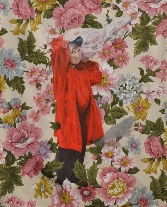 Figura a figura intera con cappotto rosso e pantaloni scuri, con un velo bianco semitrasparente sollevato sopra la testa, su uno sfondo di grandi fiori rosa, gialli e azzurri.