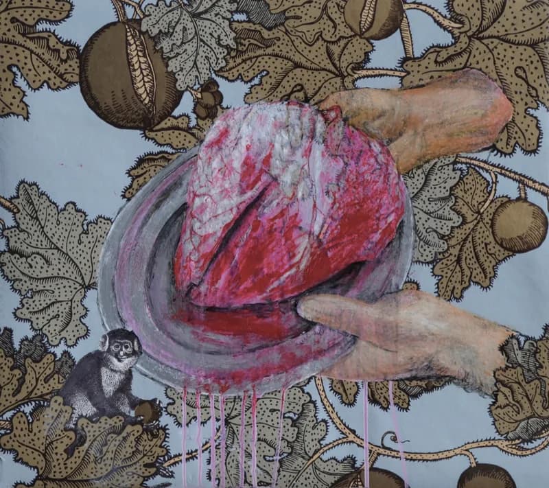 Cuore anatomico rosso e rosa su un piatto ovale grigio-violaceo, stretto tra due mani, su uno sfondo azzurro con grandi foglie e frutti decorativi; in basso a sinistra compare una piccola scimmia in bianco e nero.